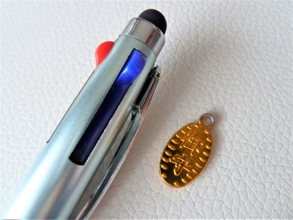 金のお守りコインとボールペン