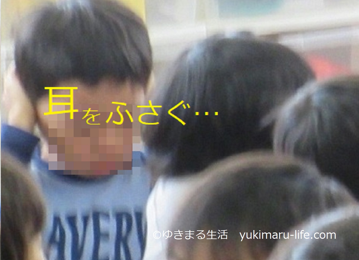耳をふさぐ男の子